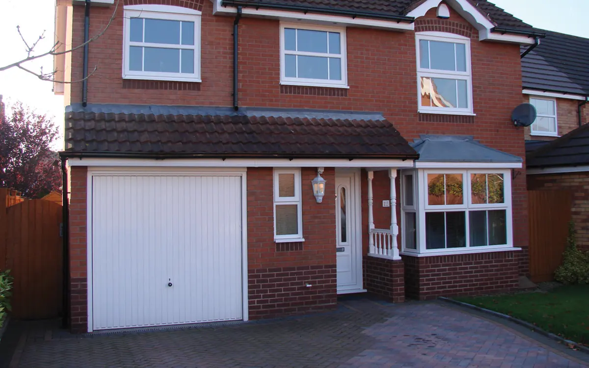 A brick house with its original white uPVC windows
